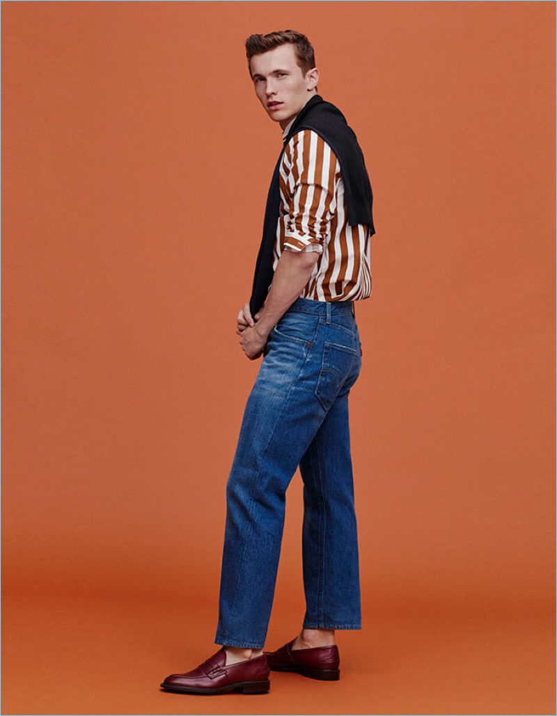 Turn Back Time: Christoffer Barsø embraces a retro attitude by pairing his jeans with leather loafers. He also dons a striped shirt and sweater tied around his neck.