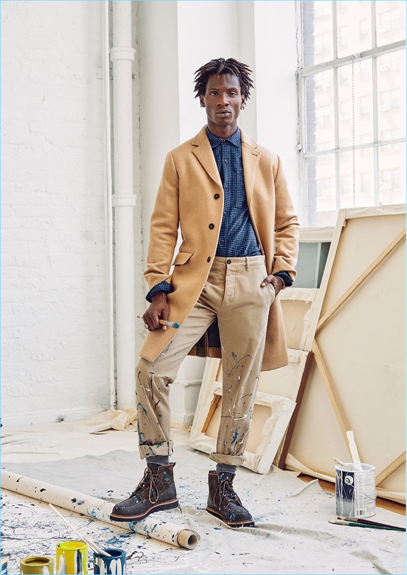 Model Adonis Bosso dons a Todd Snyder cashmere camel coat, houndstooth shirt jacket, and Japanese selvedge chino pants.