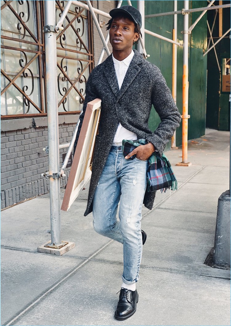 On the move, Adonis Bosso wears a Todd Snyder herringbone coat, Japanese selvedge oxford shirt and stretch jeans.