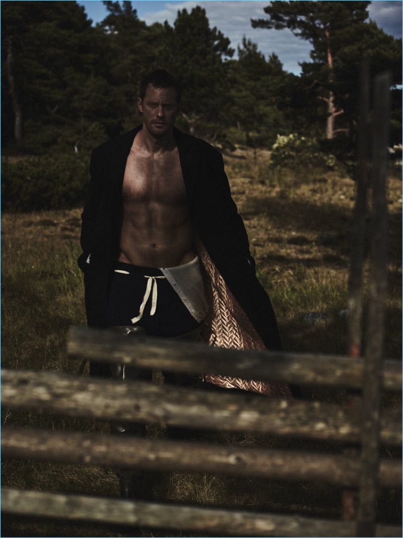 Posing for a dramatic photo, Alexander Skarsgård dons a Haider Ackermann coat, Alias Costume Rental longjohns, and Cassie Mercantile pants.