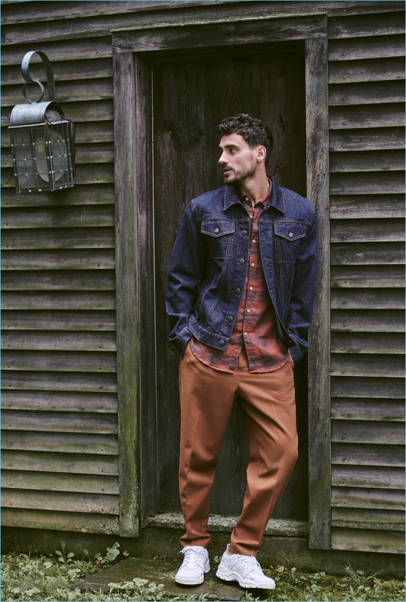 Arthur Kulkov wears a Helmut Lang denim jacket, Portuguese flannel shirt, Tomorrowland pants, and AMI sneakers.