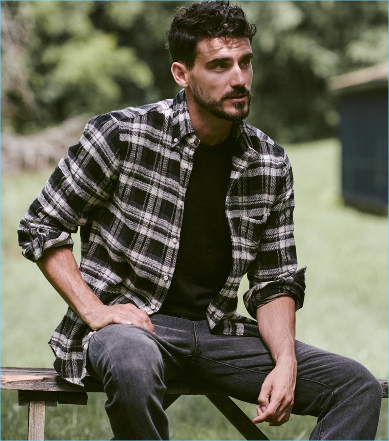 Connecting with East Dane, Arthur Kulkov wears a Vince tee and sneakers with a Gitman Vintage flannel shirt and Frame denim jeans.