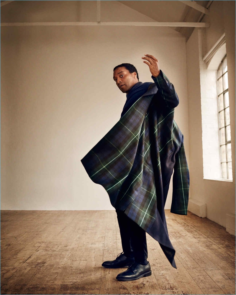 Embracing plaid, Chiwetel Ejiofor sports a Paul Smith coat and sweater with Acne Studios jeans and Mr P. derby shoes.