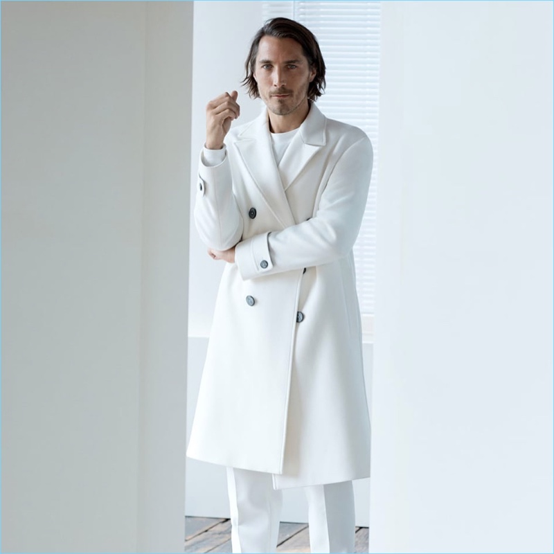 Sporting winter white, Guillaume Macé appears in an editorial for Zara.