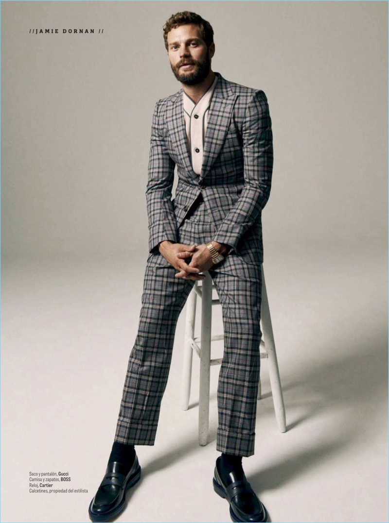 A dapper vision, Jamie Dornan dons a check Gucci suit with a shirt and shoes by BOSS. He also sports a Cartier watch.