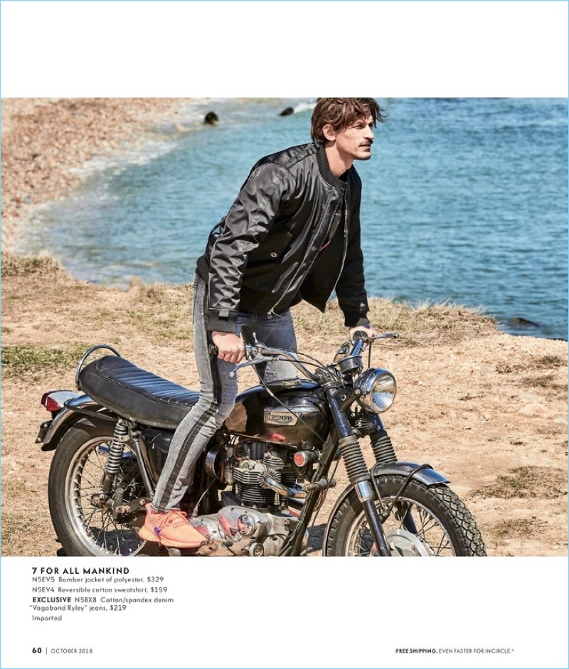 Australian model Jarrod Scott wears a 7 For All Mankind bomber jacket, sweatshirt, and denim jeans.