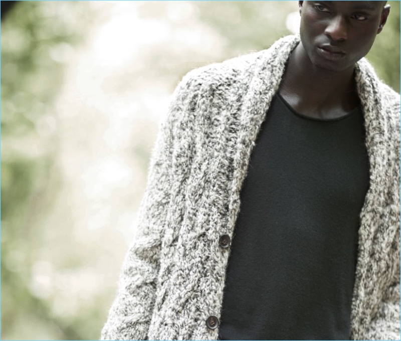 Embracing warm layers, Aly Ndiaye wears a cardigan sweater from John Varvatos.