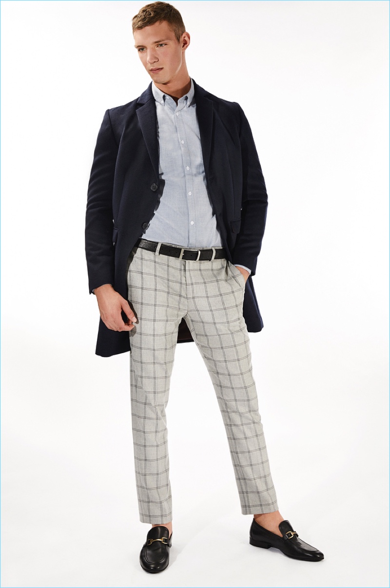 Wiktor Sudol dons a River Island overcoat with a flannel shirt and windowpane print suit pants.