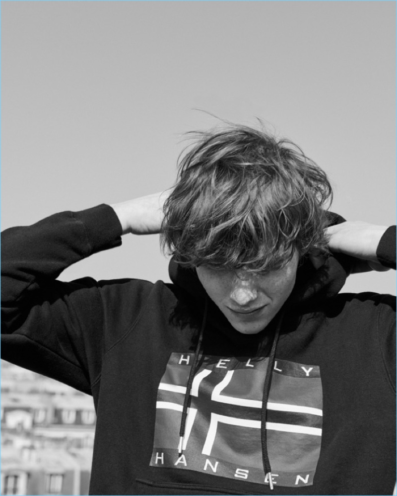 Embracing a sporty look, Noah Bunink wears a hoodie from Sandro's Helly Hansen collaboration.