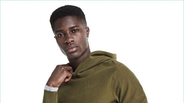 Model James Kakonge rocks a Todd Snyder + Champion hoodie with Todd Snyder corduroy trousers.