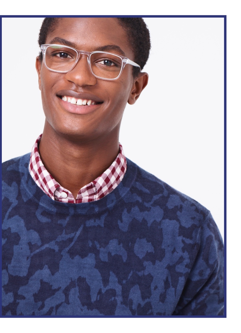 All smiles, Hamid Onifade sports Warby Parker Bensen glasses, which feature a clear frame.
