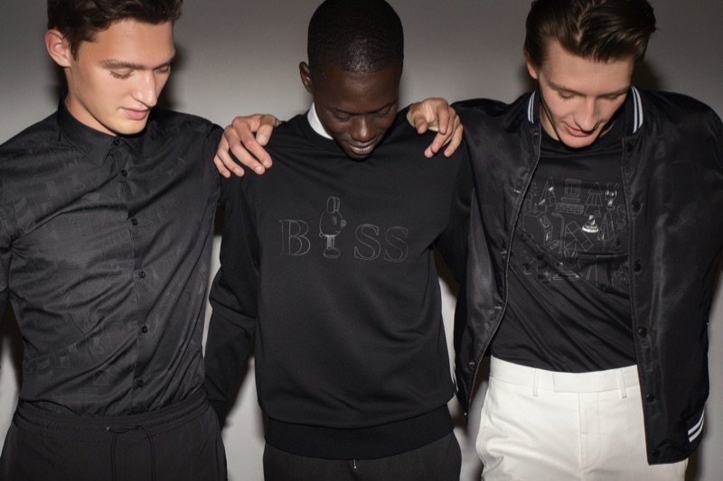 Models Otto Lotz, Alpha Dia, and Finnlay Davis showcase must-haves from the BOSS x Jeremyville holiday collection.