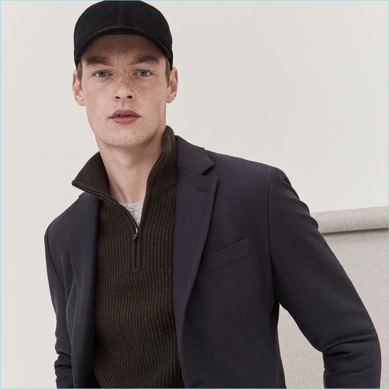 Roberto Sipos sports a Banana Republic ribbed half-zip sweater, blazer, and corduroy logo cap.