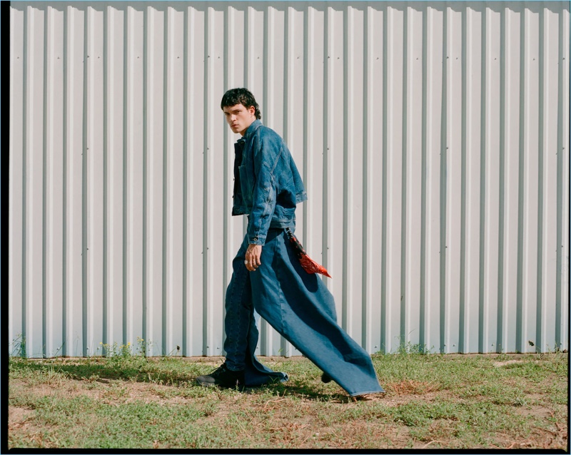 Luka Isaac dons a denim jacket and jeans by Diesel Red Tag with an AMIRI keyring and ROA sneakers.