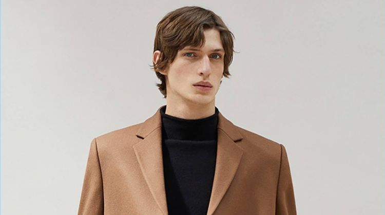 Edoardo Sebastianelli dons a brown coat and mock turtleneck sweater from COS.