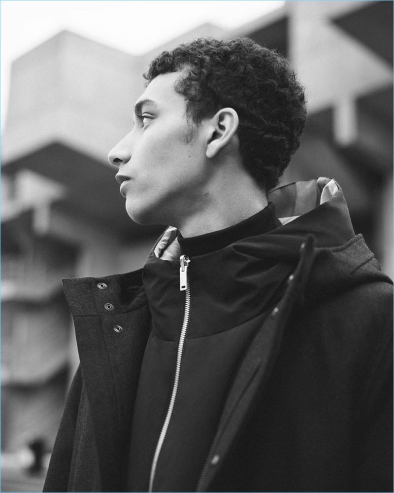 Appearing in a black and white photo, Jackson Hale wears a high-collar tailored jacket and wool anorak from COS.