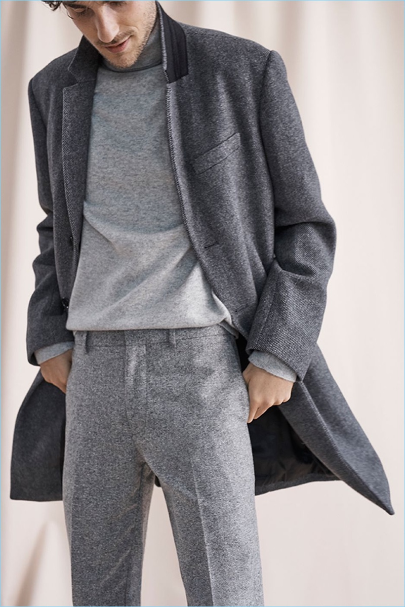Dressed in shades of grey, Hamilton Seguin sports a Club Monaco cashmere turtleneck, trousers, and a twill topcoat.