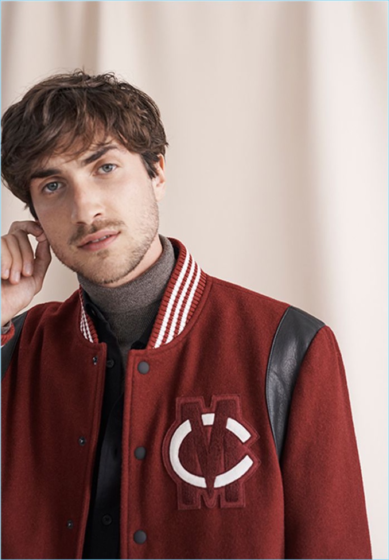 Embracing collegiate style, Hamilton Seguin dons a Club Monaco varsity patch jacket and merino turtleneck.