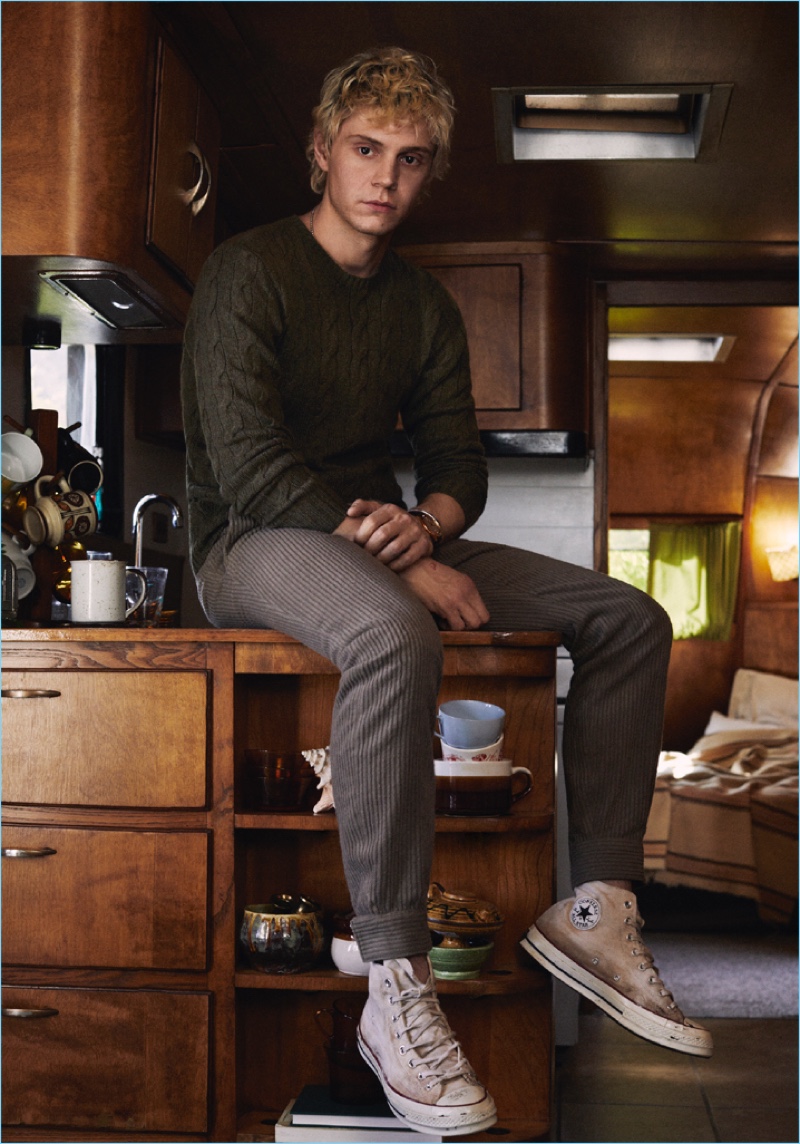 Appearing in a new photo shoot, Evan Peters dons a Ralph Lauren sweater with Ermenegildo Zegna trousers and Converse sneakers.