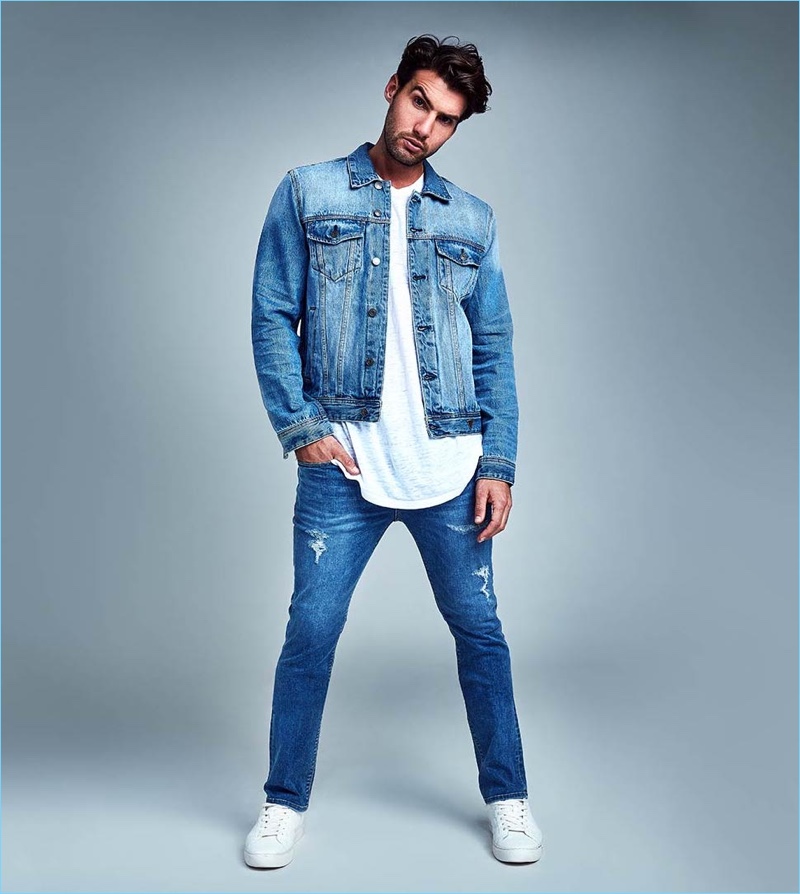 Australian model Mitchell Wick sports slim taper-fit jeans by GUESS.