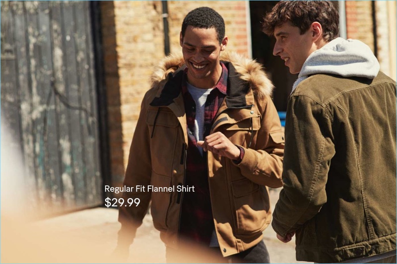 Models Cameron Gentry and Adrien Sahores sport outdoors-inspired style for H&M. Left to Right: Cameron wears a short hooded jacket, flannel shirt, and t-shirt. Adrien sports a corduroy trucker jacket and hoodie.
