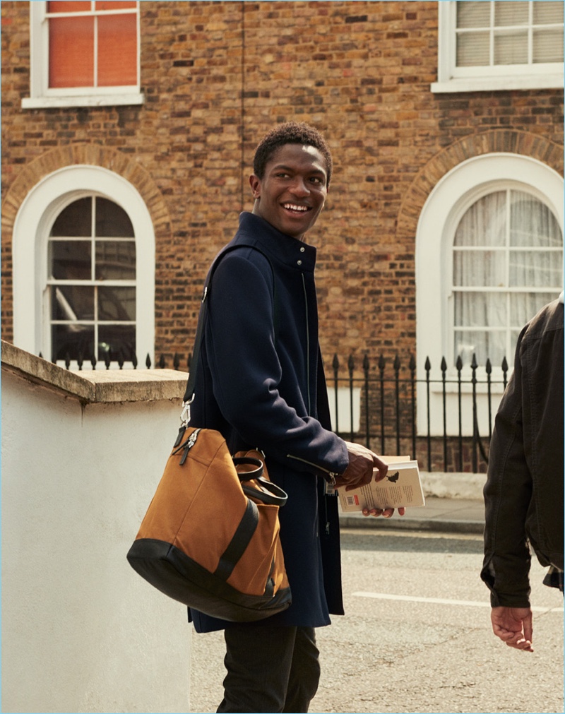 Hamid Onifade dons a coat with a stand-up collar.