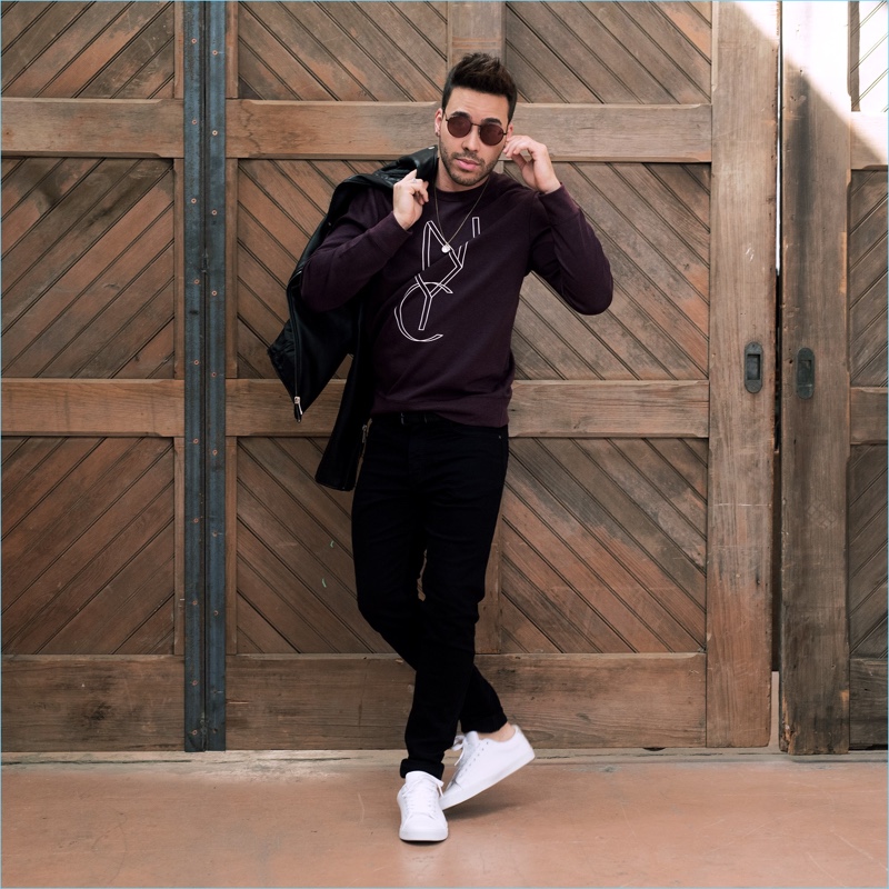 Taking hold of a H&M biker jacket, Prince Royce wears black jeans and white sneakers.