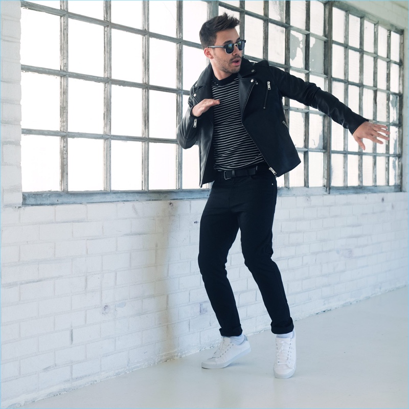 A cool vision, Prince Royce wears a biker jacket, skinny black jeans, white sneakers, a striped sweater from H&M.