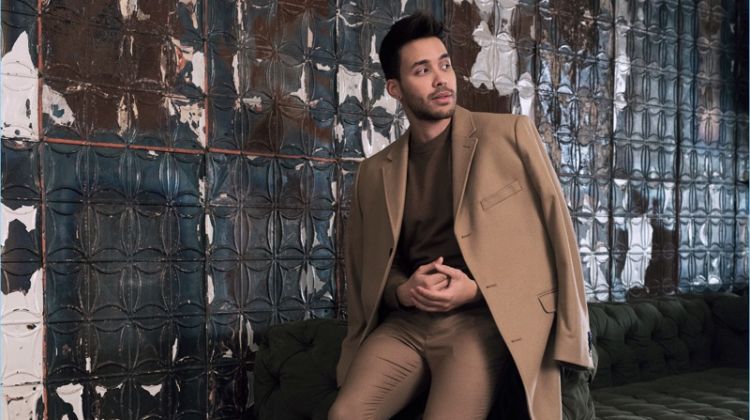Singer Prince Royce dons a wool-blend camel coat with a fine-knit sweater, and suit pants by H&M.