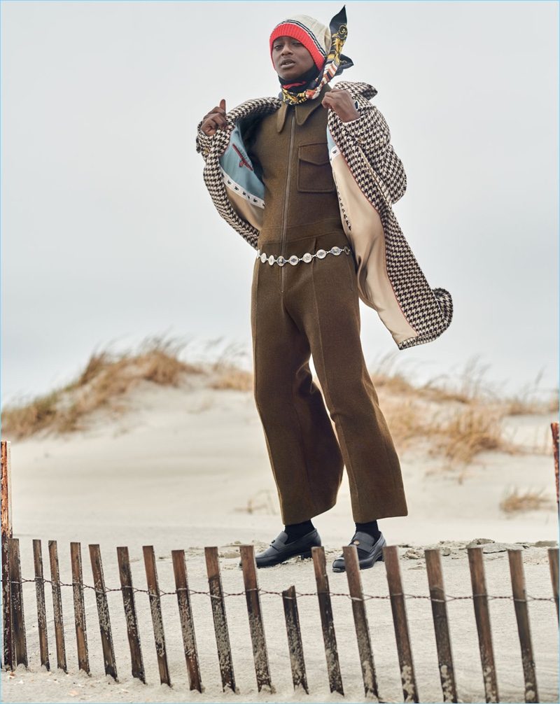 Front and center, Buddy wears a houndstooth coat, knit beanie, and other clothing by Gucci.