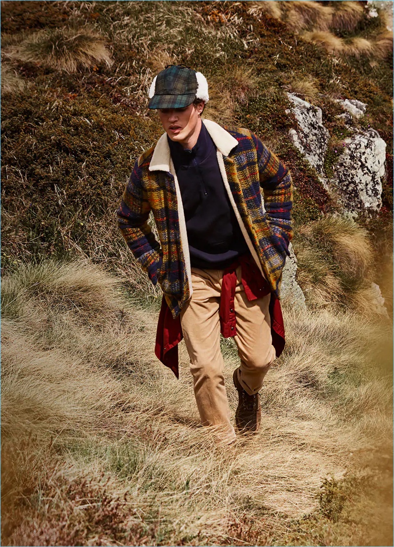 Starring in Scotch & Soda's fall-winter 2018 campaign, Benjamin Reynier wears a checked wool jacket. Venturing outdoors, he also sports a half-zip pullover, garment-dyed shirt, corduroy trousers, and a checked trapper hat.