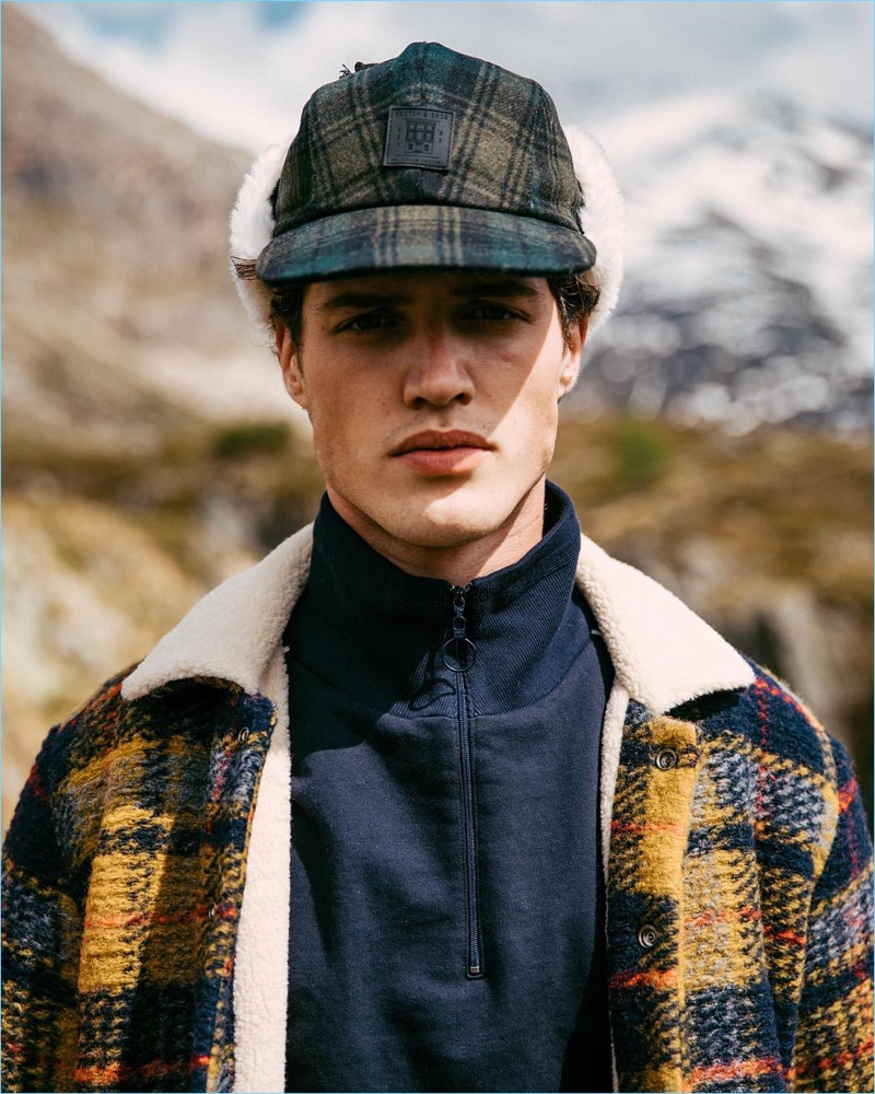 Front and center, Benjamin Reynier models a Scotch & Soda checked wool jacket and trapper hat with a half-zip pullover.