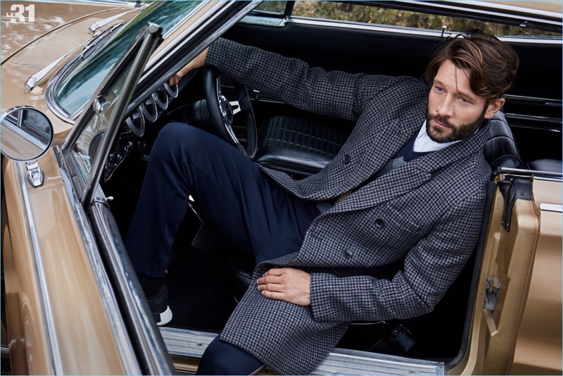 Relaxing in a vintage car, John Halls dons a LE 31 check overcoat, argyle sweater, officer collar shirt, , and piqué-stripe athletic pants.