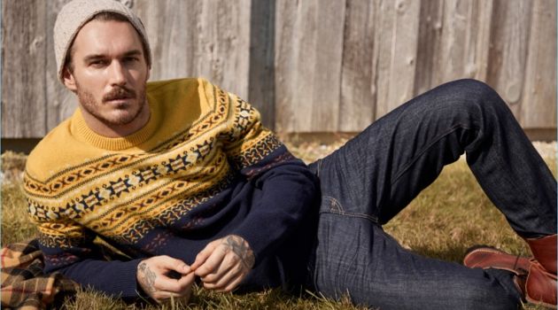 Simons Navigates This Season's Sweaters with David Alexander Flinn Relaxing, David Alexander Flinn wears a LE 31 Scandinavian jacquard sweater and knit beanie with Levi's deep indigo 511 jeans.