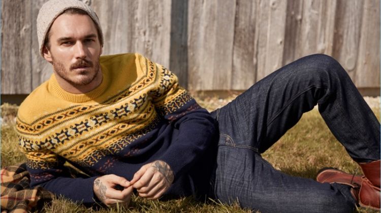 Relaxing, David Alexander Flinn wears a LE 31 Scandinavian jacquard sweater and knit beanie with Levi's deep indigo 511 jeans.