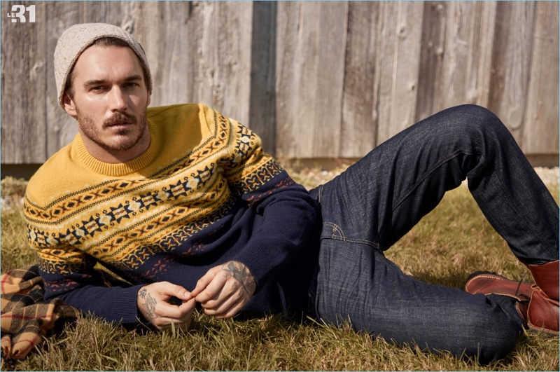 Relaxing, David Alexander Flinn wears a LE 31 Scandinavian jacquard sweater and knit beanie with Levi's deep indigo 511 jeans.