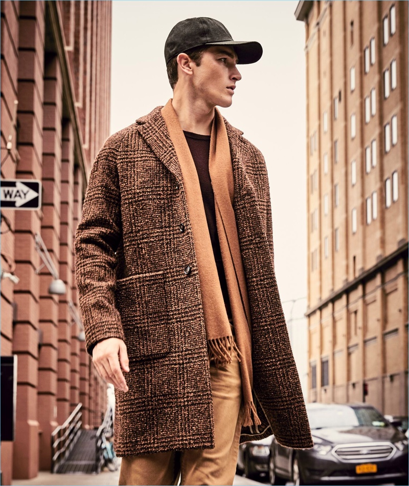 British model Oli Lacey wears a Todd Snyder Italian wool bouclé Glen Plaid topcoat in brown.