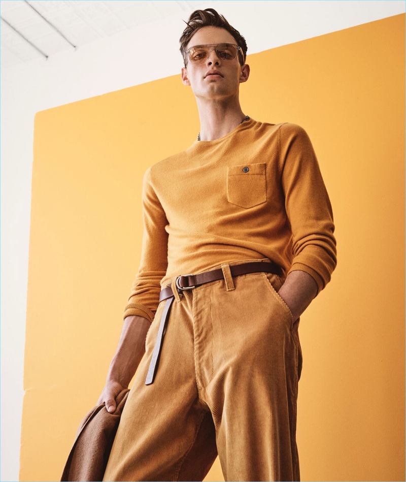 Making a colorful statement, Rocky Harwood wears a gold yellow cashmere t-shirt sweater from Todd Snyder.