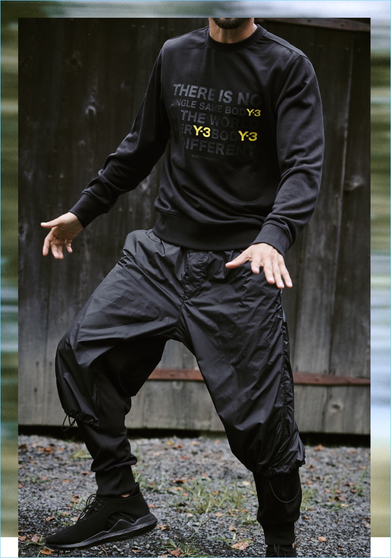 Model Arthur Kulkov sports a Y-3 sweatshirt, nylon mix track pants, and Saikou sneakers.