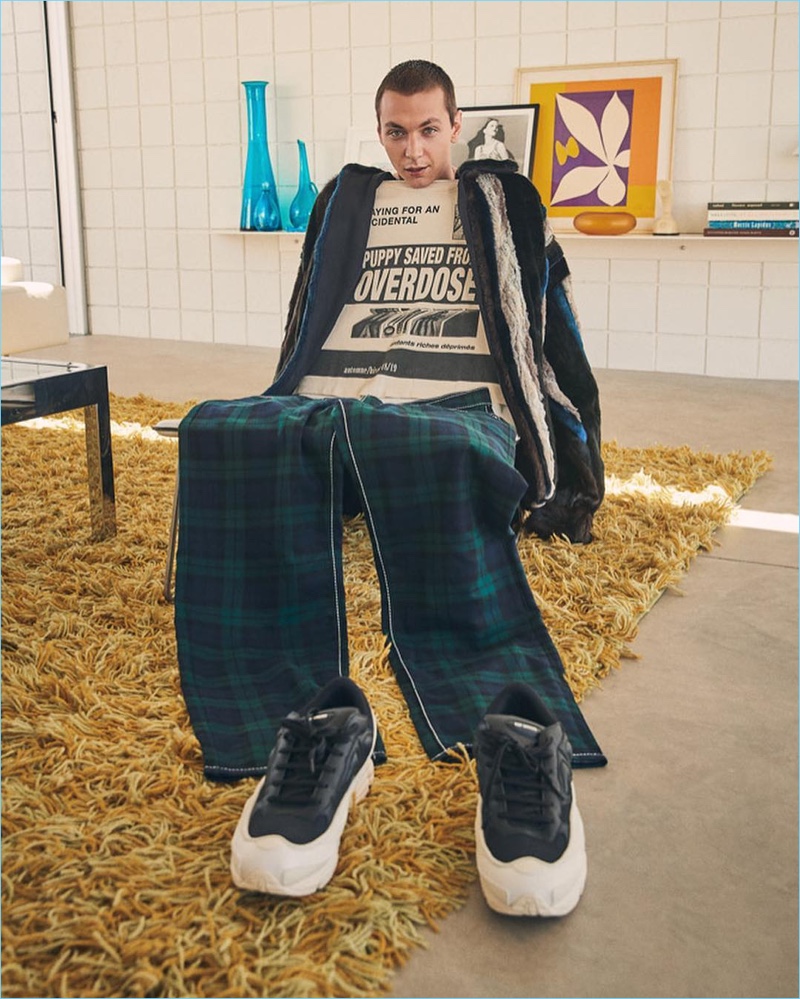 Model Yuri Pleskun poses against a Y/Project faux fur shirt, Enfants Riches Deprimes tee, and EYTYS tartan pants.