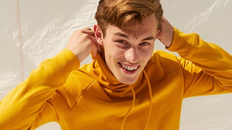 Kit Butler rocks a yellow fleece funnel neck hoodie from Express.