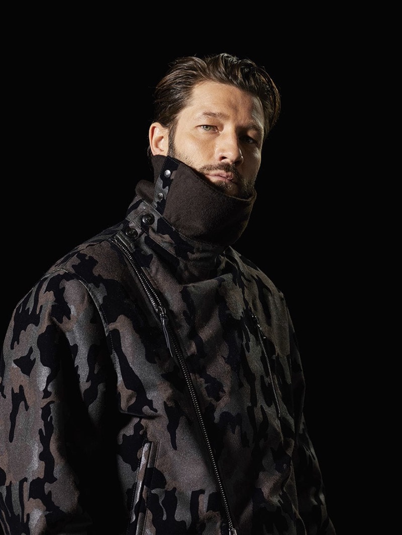 John Halls sports a camouflage print funnel neck jacket from Giorgio Armani.