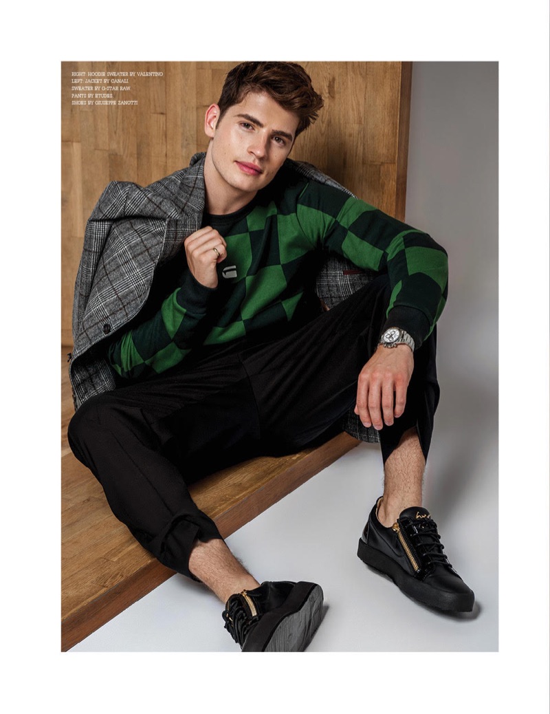 Actor Gregg Sulkin dons a Canali suit jacket, G-Star Raw sweater, Etudes pants, and Giuseppe Zanotti sneakers.