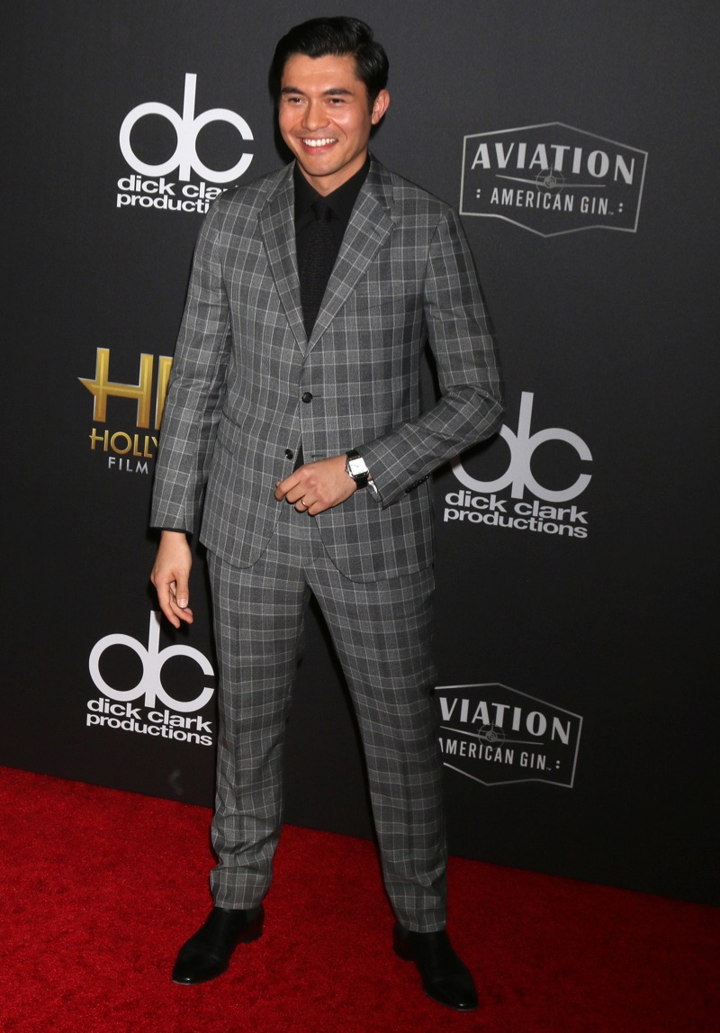 Attending the Hollywood Film Awards, Henry Golding dons a grey check suit by Versace.