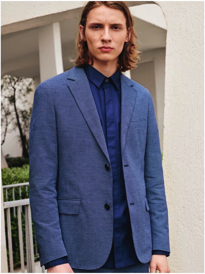 Gabriel Besnard dons a blue suit jacket and shirt from Lacoste's spring-summer 2019 collection.