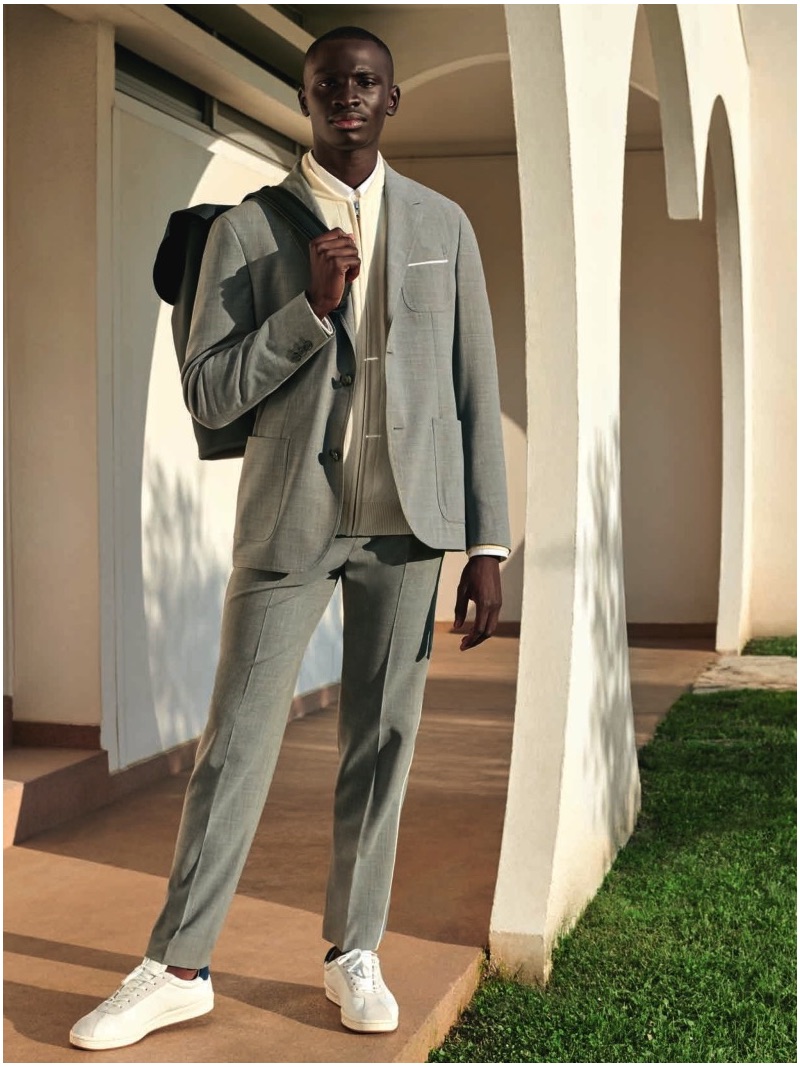 A smart vision, Ambroise Mendy wears a suit and white sneakers by Lacoste.