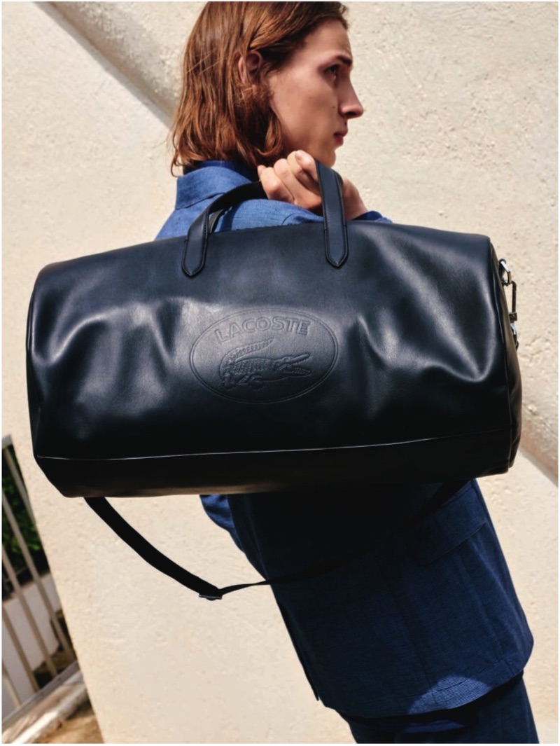 Taking hold of a leather bag, Gabriel Besnard appears in Lacoste's spring-summer 2019 lookbook.