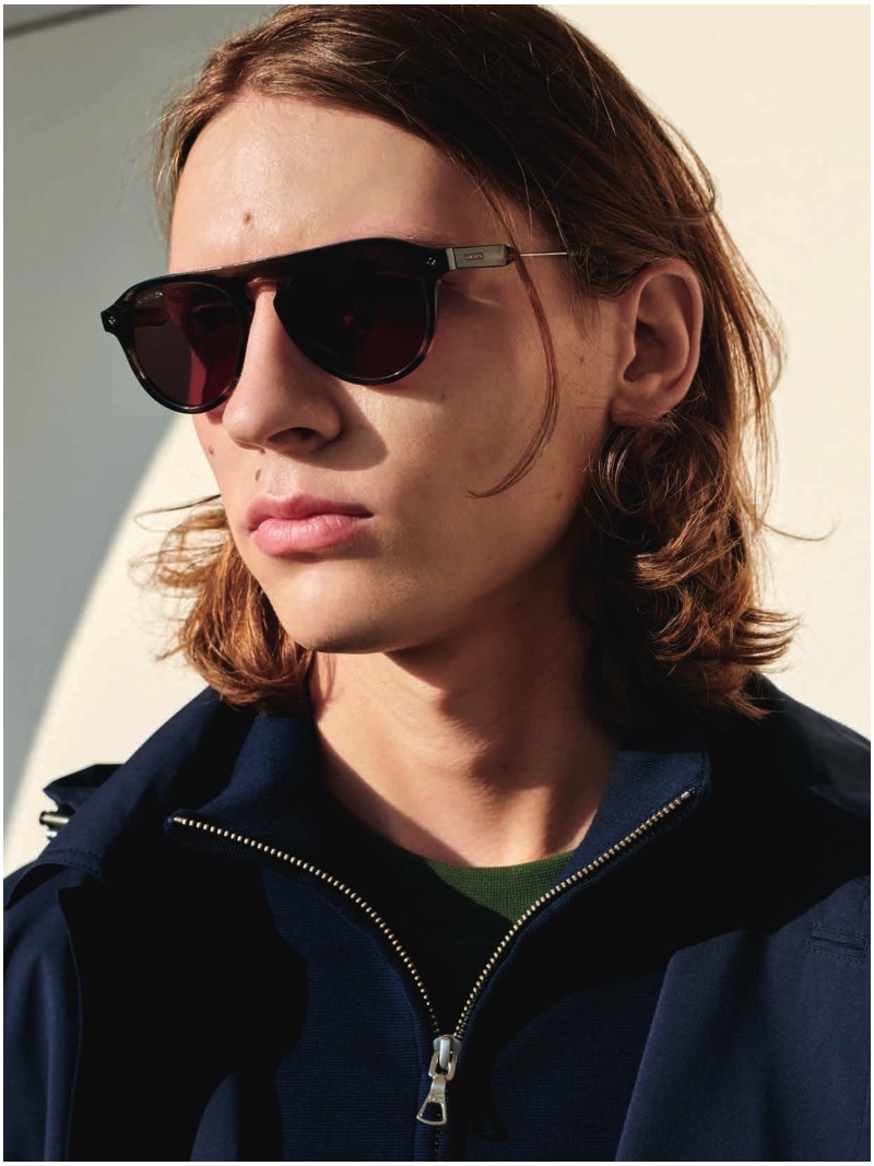 Model Gabriel Besnard sports shades and a pullover by Lacoste.