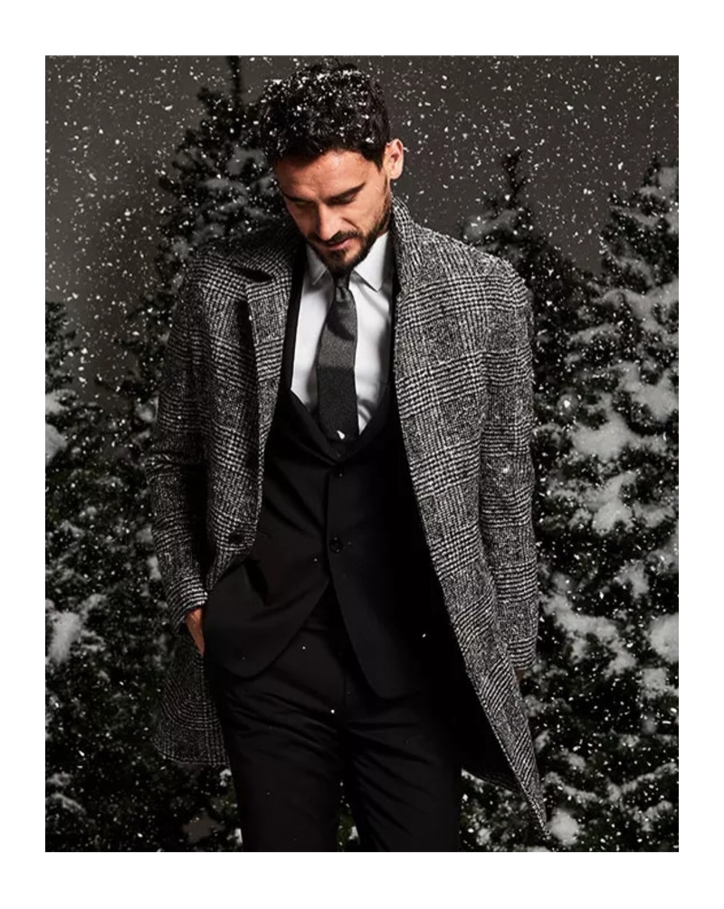 Office Holiday Party: Embracing menswear classics, Arthur Kulkov is pictured in a Michael Kors Glen Plaid topcoat with a Calvin Klein black suit jacket and pants.