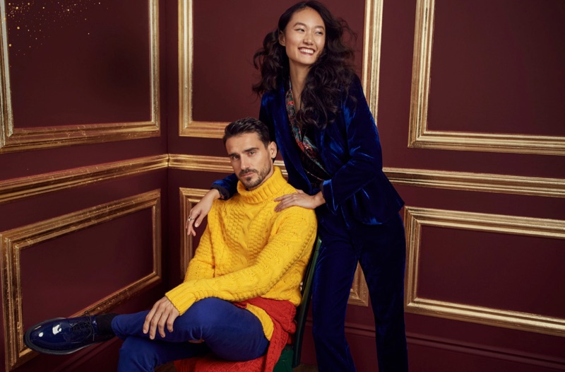 Making a colorful splash, Arthur Kulkov wears a yellow turtleneck sweater and colored jeans from LE 31. In addition to Calvin Klein sapphire blue shoes, Arthur sports another LE 31 sweater tied around his waist.